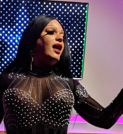 A drag performer sings A drag performer sings