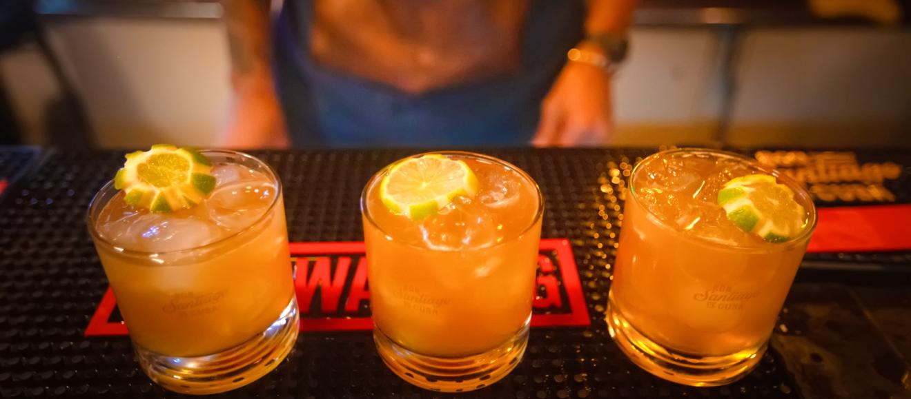 Close up of three lime garnished cocktails on a bar mat