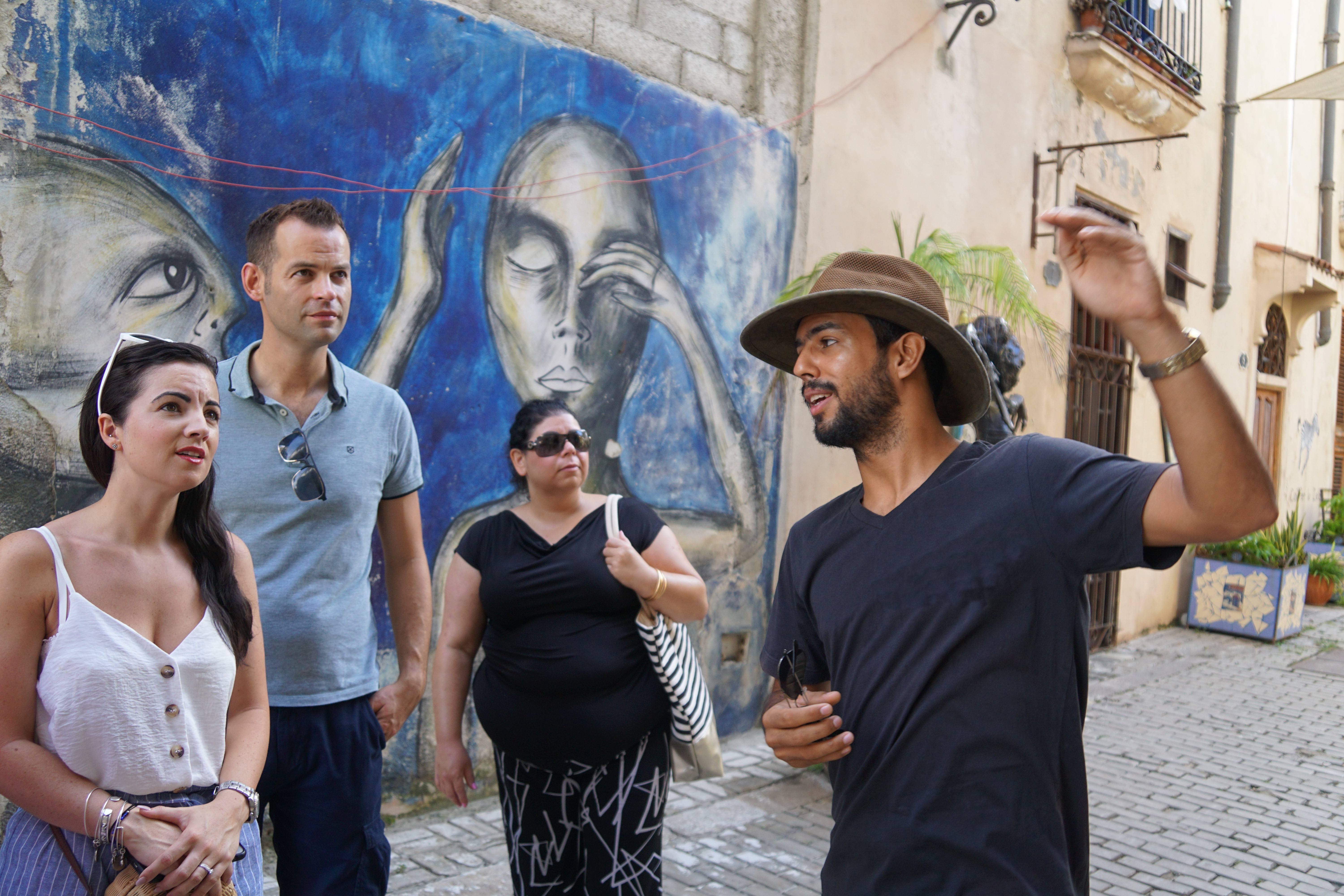 Cuban Adventures tour leader talking to group by wall mural Cuban Adventures tour leader talking to group by wall mural