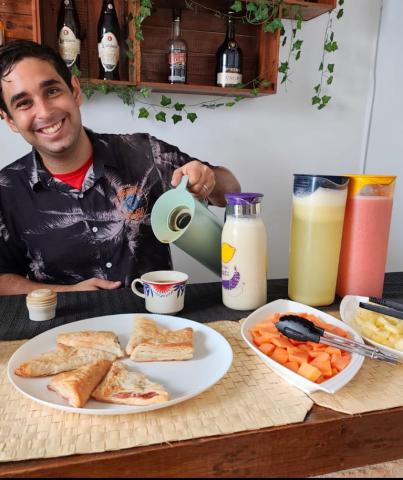 Host serving a colorful Cuban breakfast spread at Malecon Sunset guesthouse in Havana
