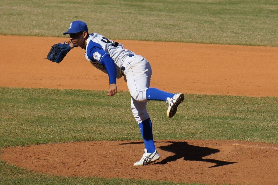 a baseball player pitches a ball