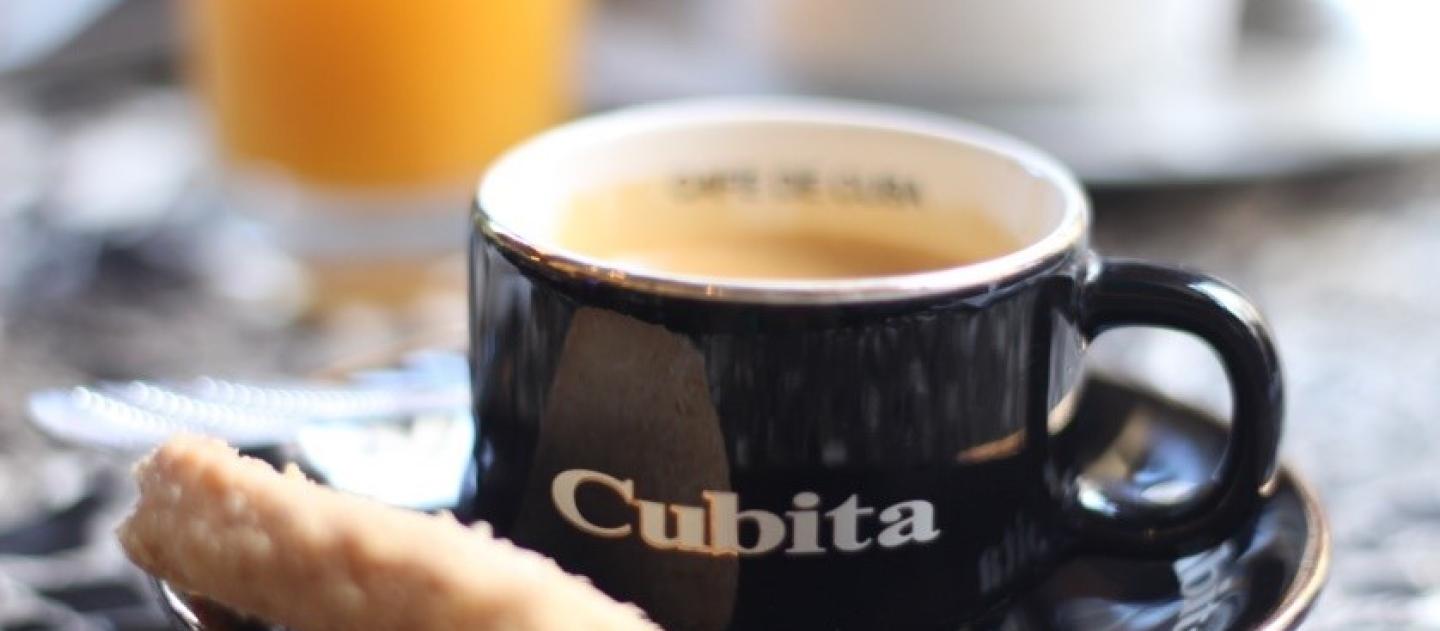a cup of coffee served on a saucer with a cookie