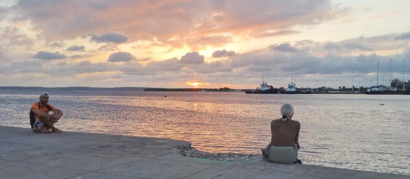 Pôr do sol sobre o bulevar à beira da baía em Cienfuegos